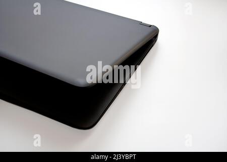 Right side detail of half closed slate grey laptop on white background Stock Photo