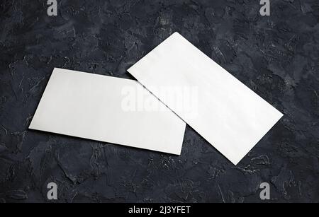 Blank white paper envelopes on black plaster background. Template for your design. Stock Photo
