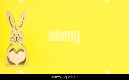 Easter . Easter, wooden bunny on a yellow background.Banner copy space. Stock Photo
