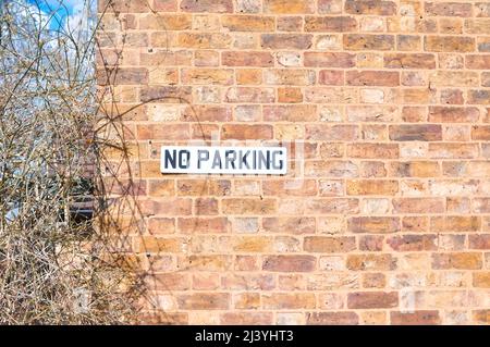 Sign no parking for drivers in the brick wall in England  Stock Photo