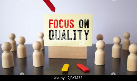 The wooden man and white cloud with text Focus on Quality. The content of the lettering has implications for business concept and marketing. Stock Photo