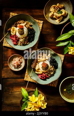 Nasi Campur Babi Guling. Balinese meal of rice with roast pork, other pork and vegetable dishes Stock Photo
