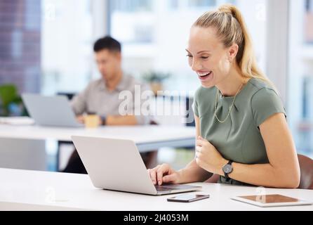 I did it. Shot of an attractive young businesswoman sitting in the office and using her laptop. Stock Photo