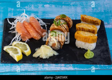 Assorted Sushi and Sashimi Platter. Salmon Sushi Rolls, Salmon Sashimi, Wasabi, Ginger, Lemon. Stock Photo