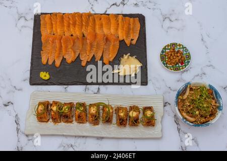 Salmon Sushi Rolls Platted On A White Marble Table. Image can be utilized editorially or commercially. Stock Photo