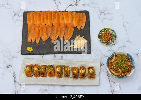 Salmon Sushi Rolls Platted On A White Marble Table. Image can be utilized editorially or commercially. Stock Photo