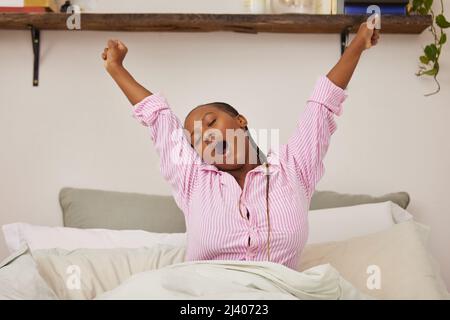 The rest of your life awaits. Shot of a young woman waking up and stretching in bed at home. Stock Photo