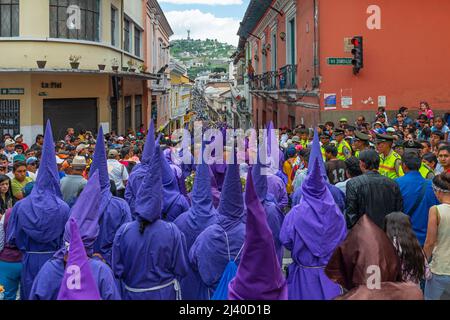 Cucurucho penitents in traditional purple costume with pointy hats during the Good Friday Easter procession in the streets of Quito, Ecuador. Stock Photo