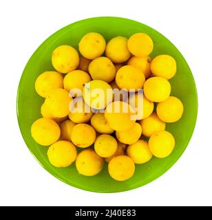 wet yellow cherry plum in bowl, isolated above Stock Photo