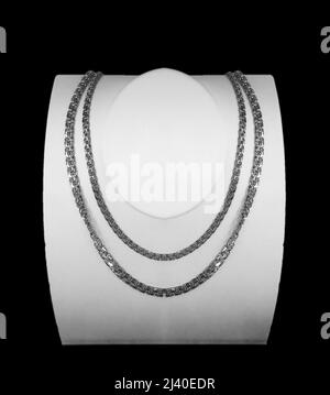 white metal chains on displays manikin, isolated on black Stock Photo