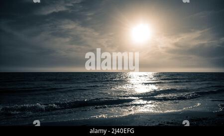 sunset cloudy sky over cold stormy sea Stock Photo