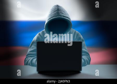 Russian Hacker attack. Dangerous Hooded Hacker Breaks into Government Data Servers. Cybersecurity, computer hacker with hoodie. Hacking and malware co Stock Photo