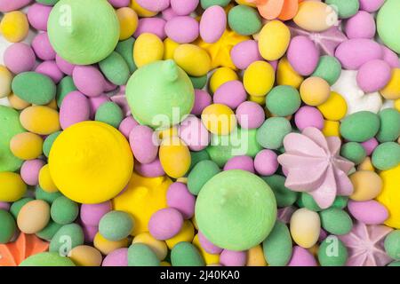 Colorful meringues and glazed peanuts isolated on a white background. Top view. Stock Photo