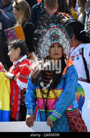 9th April 2022. London, England. London Extinction Rebellion Protest. A woman, stood with her family, wears Ecuadorian ceremonial clothing to show her Stock Photo