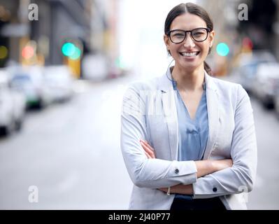Always striving for more. Shot of a young businesswoman standing in the street. Stock Photo