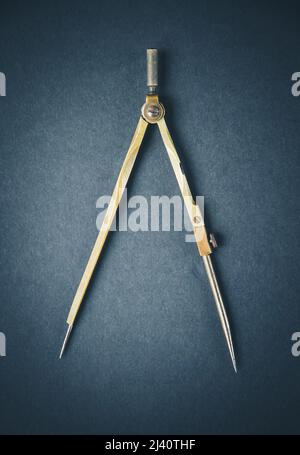 Old vintage pair of compasses on a dark background Stock Photo