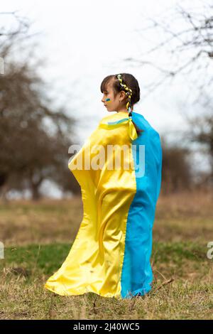 Little Ukrainian girl as a Symbol of Ukraine. Stop the war. A child with two pigtails and yellow and blue ribbons like the Ukrainian flag. Back view. Stock Photo