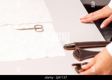 Hands of manicure master prepare nail care tools on a white table Stock Photo