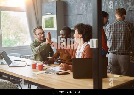 business colleagues giving each other a high five. Stock Photo