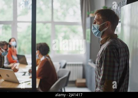 man in a protective mask standing in the hall of the coworking c Stock Photo
