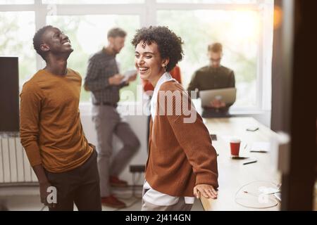 cheerful young employees standing near a table in a coworking ce Stock Photo