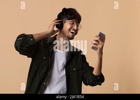 Happy hindu man enjoying newest stereo headset Stock Photo