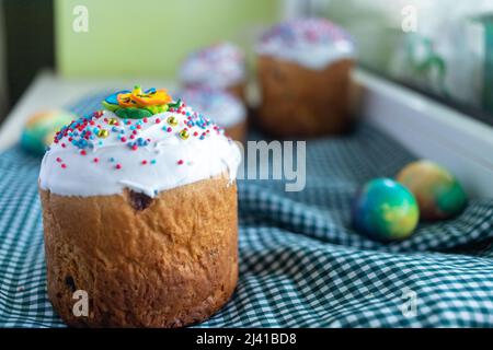 Easter composition with traditional Russian Easter bread kulich, Easter eggs and lilac flowers on table. Stock Photo