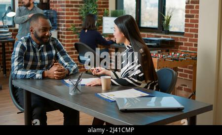 HR employee greeting job candidate at recruitment interview, talking about cv information and work offer. People shaking hands after meeting to discuss employment and job application. Stock Photo