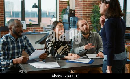 Angry employee causing scene after getting fired from job, being discharged from business career. Female worker losing work, getting dismissed by diverse group of people, experimenting failure. Stock Photo