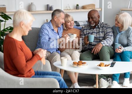 Positive multiracial senior people spending time together at retirement house Stock Photo