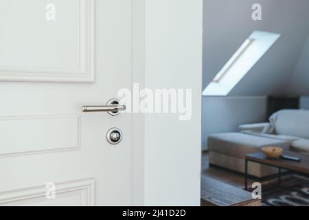 Hotel apartment door, white wooden doorway with metal handle, selective focus