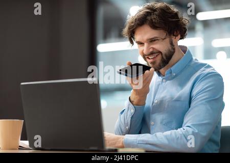Smiling man working and talking on phone at office Stock Photo