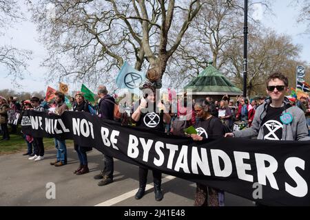 London, UK. 10th Apr, 2022. People hold a banner that reads 'we will not be bystanders'. Extinction Rebellion (XR) activists gathered in Hyde Park and marched through Central London, the march split in two and Lambeth bridge and Vauxhall bridge were blocked. Multiple people glued themselves to the road in Vauxhall junction and multiple arrests were made following. Credit: Dan Pearson/Alamy Live News Stock Photo