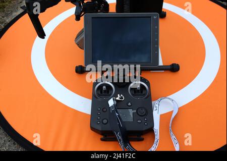 Remote control panel with monitor for a pro quadcopter placed on the landing pad before working. Stock Photo