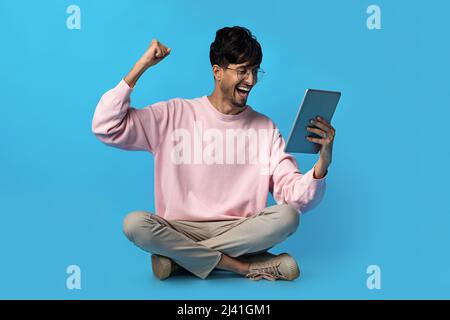 Happy middle eastern young man using digital tablet Stock Photo