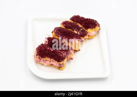 Eclair cake with raspberry isolated on white background. Close-up. Stock Photo