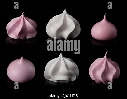 Meringue cookie set isolated on black background. Twisted sweet crispy curly white and pink meringue with reflection. Stock Photo