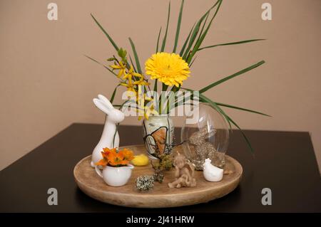 Easter scene with yellow and orange, spring flowers and decorative easter bunnies, angel and chicken Stock Photo