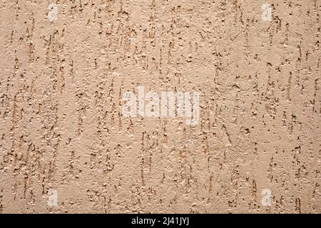 The texture of the Rough concrete wall with irregularities, painted in beige color Stock Photo
