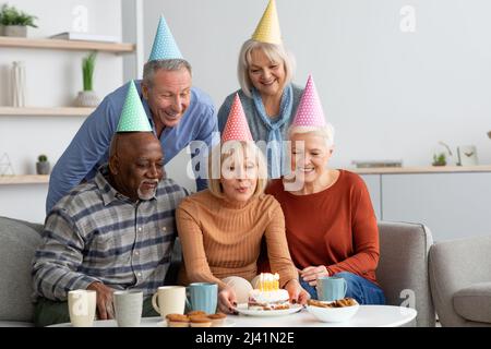 Multiracial group of elderly people having birthday party at home Stock Photo