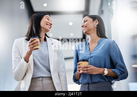 They told us that we couldnt, so we did. Shot of two businesswomen holding coffees while talking in an office. Stock Photo