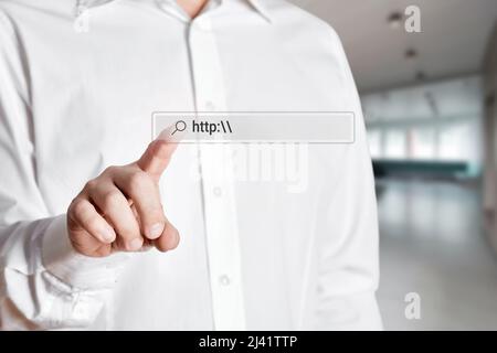 Businessman press the search icon on the internet search bar on a virtual screen with the word http. Internet search concept. Stock Photo
