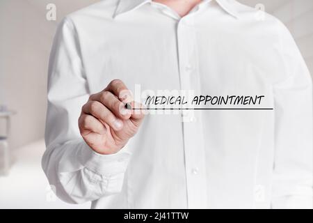 Man with pen writes the words medical appointment on a virtual screen. Stock Photo