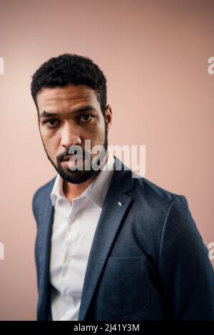 Serious young businessman looking at camera, studio shot. Stock Photo