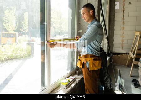 Construction worker installing window in house Stock Photo