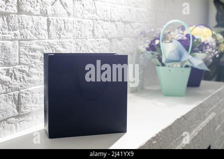 black empty paper bags and bouquets. Blank wall Stock Photo