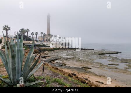 The coast of Chipiona, a tourist town in the province of Cádiz, in Spain, with the lighthouse in the background on a foggy day Stock Photo