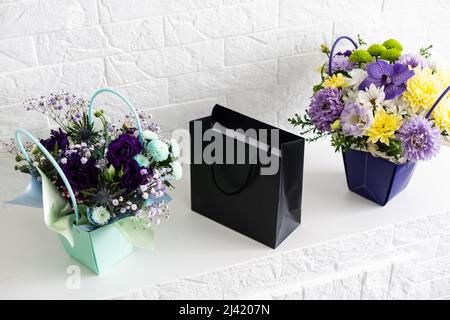 black empty paper bags and bouquets. Blank wall Stock Photo