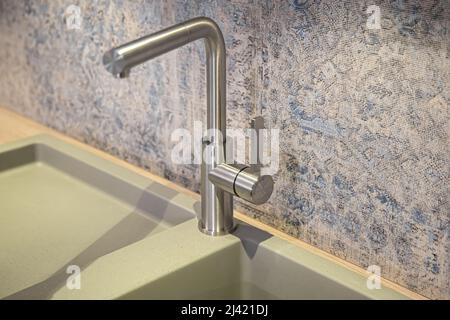 Steel faucet in the kitchen in the interior. Stock Photo