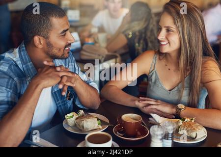 Coffee is better shared in good company. Cropped shot of a young couple on a date in a cafe. Stock Photo